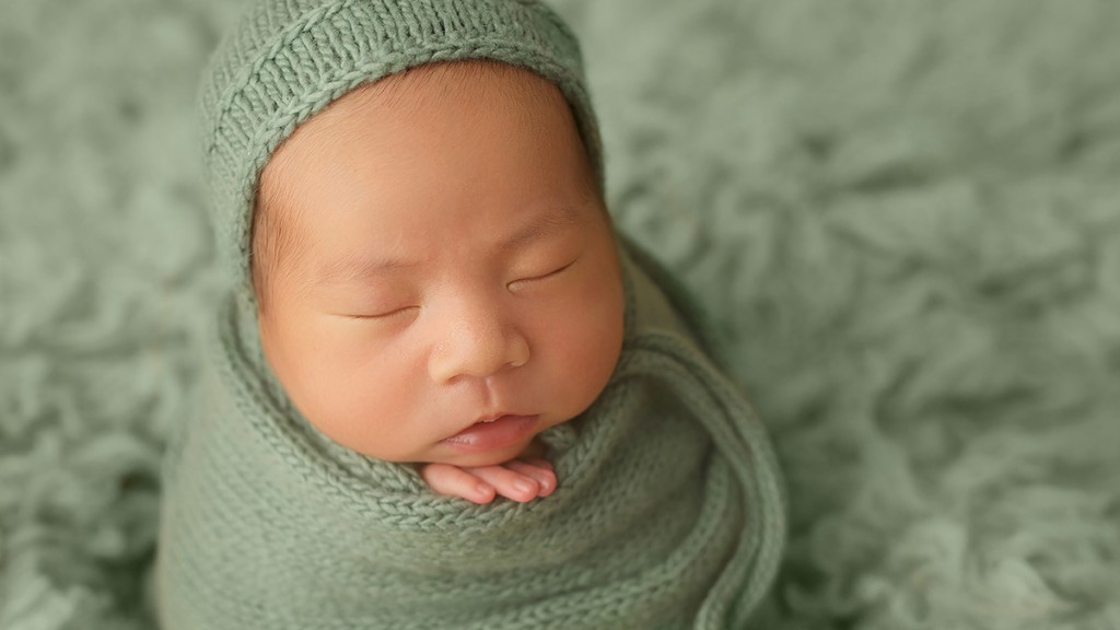 Potato Sack or tater tot is a fun image to set-up and baby loves being swaddled. Baby has grown-up hands nearby for safety, and is wrapped with three separate wraps for neck support while his hands peeking out provide chin support. Professionally posed with safety in mind always by San Marcos, Ca newborn photographer Shelly Rosen.