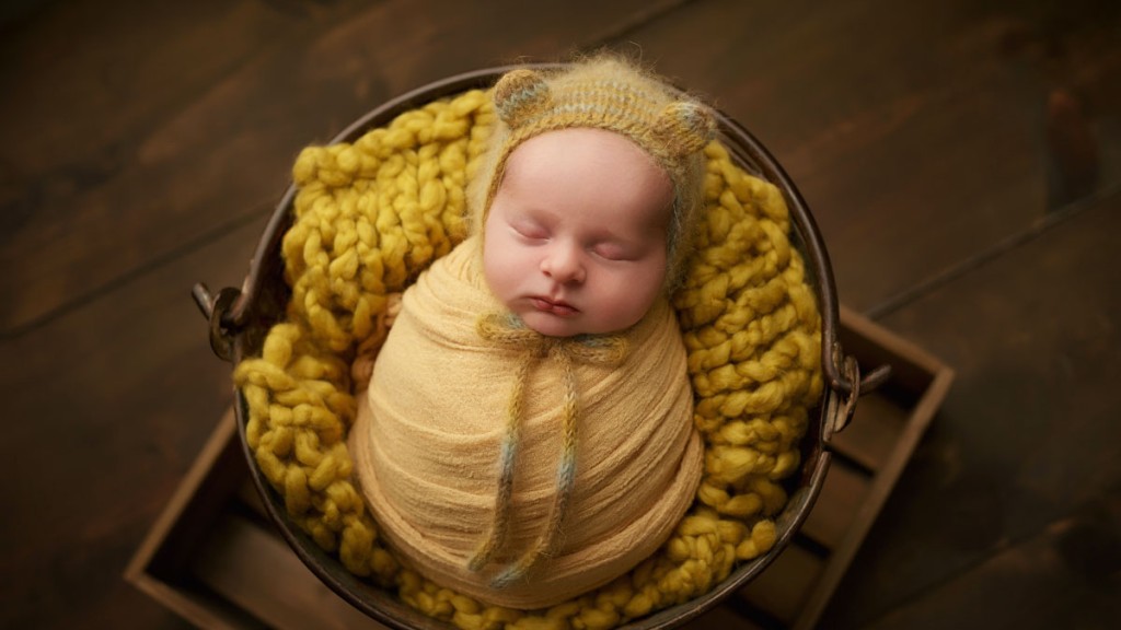 A mustard yellow wrap and teddy bear hat make this image so adorable.