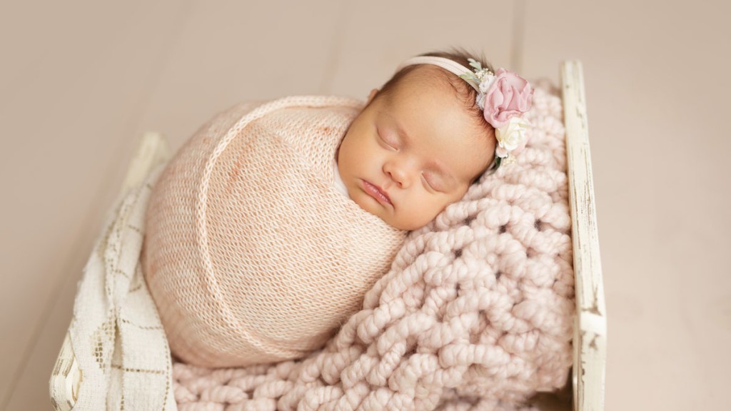 Pink and cream for a baby girl is so simple and sweet. A tiny bed holds this sleeping newborn baby posed by a San Marcos newborn photography expert.