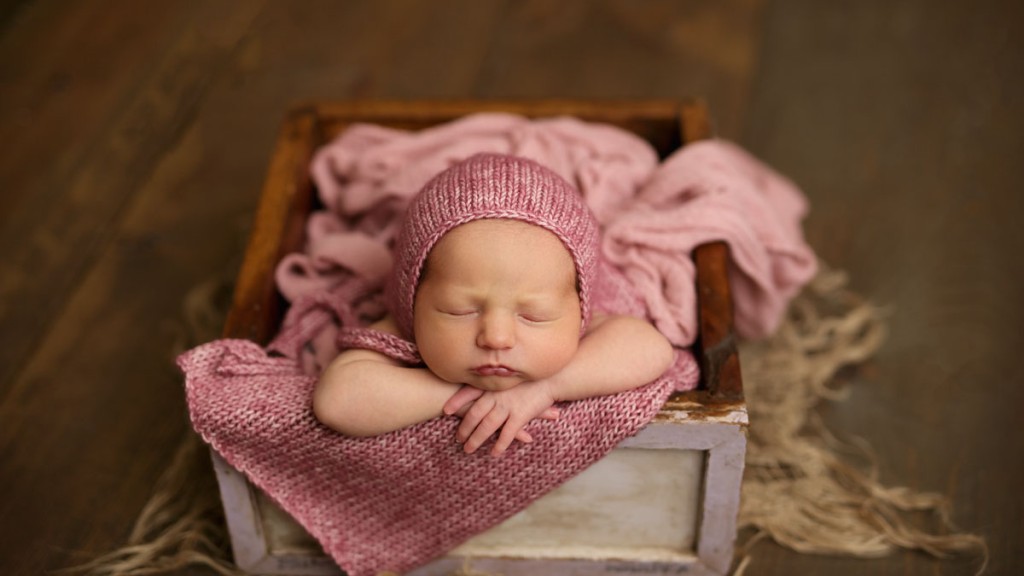 Beautiful knot berry wrap on a beautiful baby girl posed in a drawer. Mom is right next to baby for safety. Safety, happy babies and quality images are what make us proud to serve San Diego newborn photography needs.