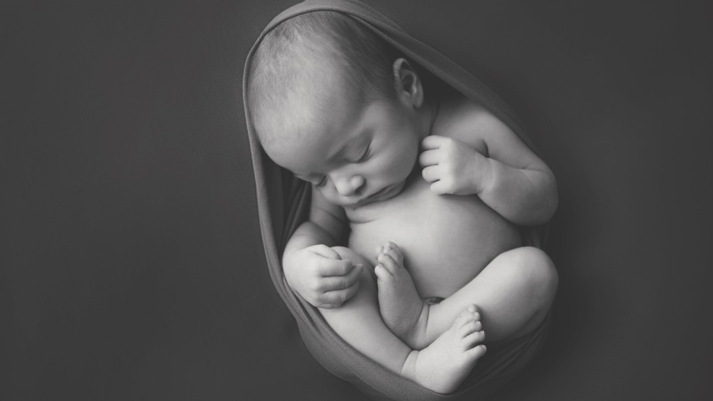 Super sweet image of a nwborn baby boy. Baby is wrapped all around so he looks like he may still be in the womb. San Diego newborn baby photographer Shelly Rosen has a portrait studio in San Marcos, Ca.