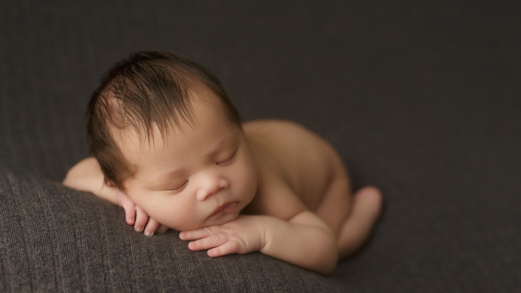 Shelly Rosen is worth the drive to San Marcos to get poses like this sweet forward facing pose on gray fabric made in her San Marcos, ca newborn photography studio.