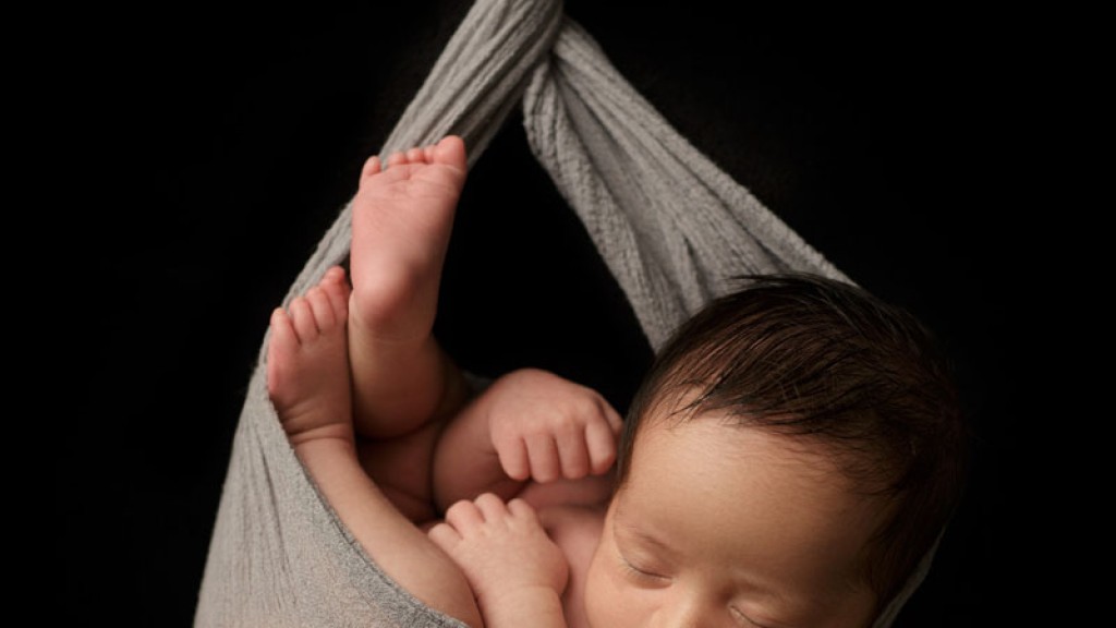 This baby boy appears to be hanging inthe folds of a muslin wrap, but is he? No, I do not actually dangle babies, this is an illusion created by skillful posing and post-processing. San Marcos, ca newborn photography is done safely and with great love and care in my San Diego newborn photography studio.